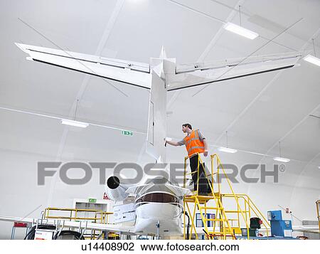Engineer inspecting jet aircraft View Large Photo Image Stock Image - Engineer inspecting jet aircraft. Fotosearch