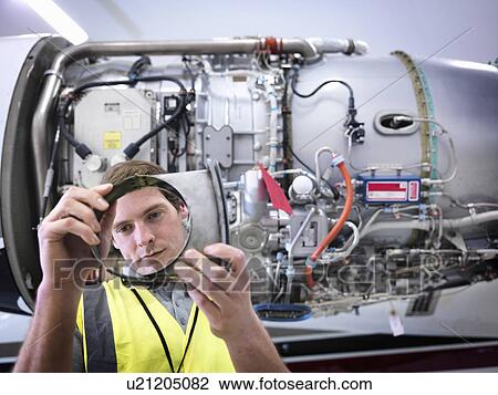 Engineer inspecting part of jet engine View Large Photo Image Stock Image - Engineer inspecting part of jet engine. Fotosearch