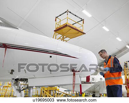 Engineer inspects jet aircraft View Large Photo Image Stock Image - Engineer inspects jet aircraft. Fotosearch