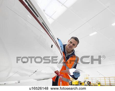 Stock Photo - Engineer inspects jet aircraft. Fotosearch