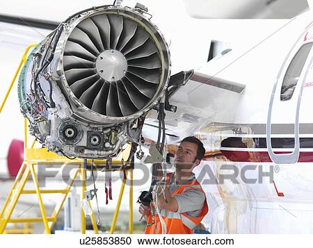 Stock Image - Engineer inspects jet engine. Fotosearch