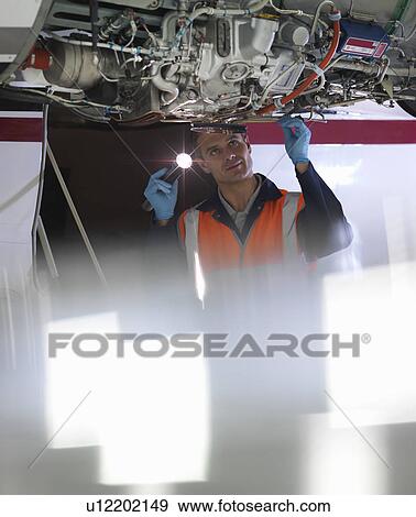 Engineer inspects jet engine View Large Photo Image Stock Photo - Engineer inspects jet engine. Fotosearch