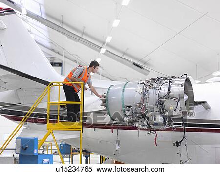 Stock Photography - Engineer inspects jet engine. Fotosearch