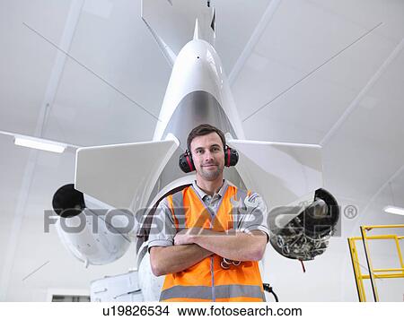 Picture - Engineer standing with jet aircraft. Fotosearch
