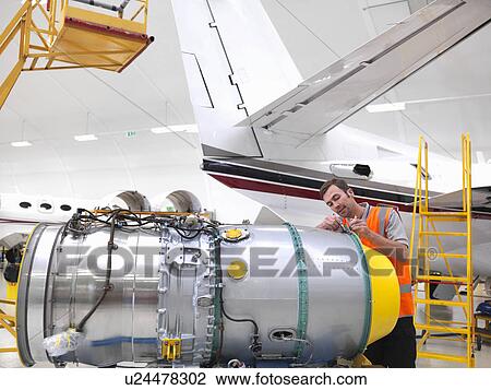 Engineer working on jet aircraft engine View Large Photo Image Stock Image - Engineer working on jet aircraft engine. Fotosearch