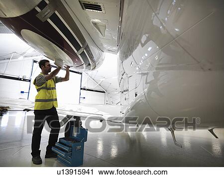 Engineer working on jet aircraft View Large Photo Image Stock Image - Engineer working on jet aircraft. Fotosearch
