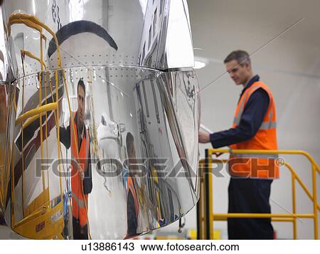 Engineer works on jet aircraft View Large Photo Image Stock Image - Engineer works on jet aircraft. Fotosearch
