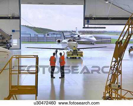Engineers in jet aircraft hangar View Large Photo Image Stock Image - Engineers in jet aircraft hangar. Fotosearch