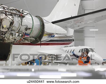 Stock Image - Engineers inspect jet aircraft. Fotosearch
