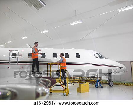 Engineers inspect jet aircraft View Large Photo Image Stock Photo - Engineers inspect jet aircraft. Fotosearch