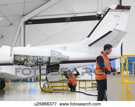 Engineers inspect jet aircraft View Large Photo Image Stock Photo - Engineers inspect jet aircraft. Fotosearch