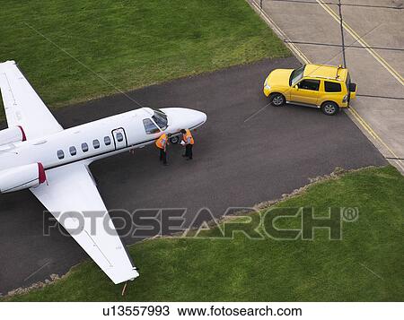 Engineers inspect jet on runway View Large Photo Image Stock Image - Engineers inspect jet on runway. Fotosearch