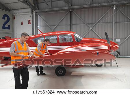 Picture - Engineers inspect turbo-prop aircraft. Fotosearch