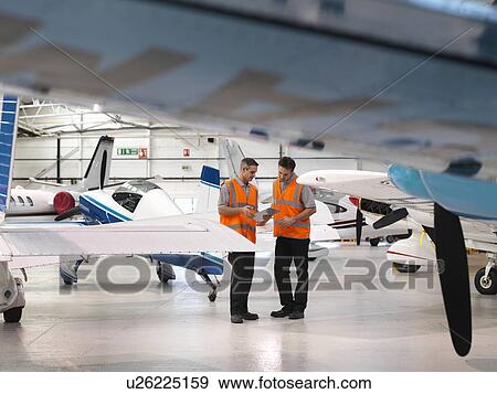 Stock Photo - Engineers inspect turbo-prop aircraft. Fotosearch