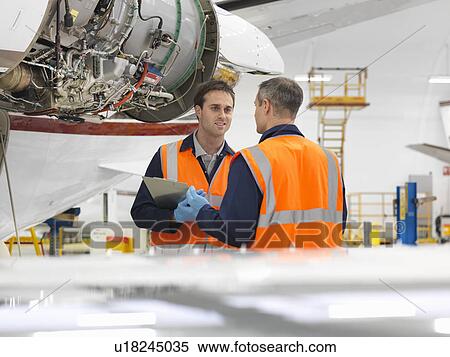 Engineers inspecting jet aircraft View Large Photo Image Stock Photography - Engineers inspecting jet aircraft. Fotosearch