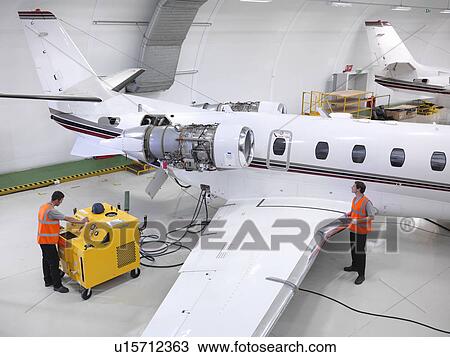 Engineers service a jet aircraft View Large Photo Image Stock Image - Engineers service a jet aircraft. Fotosearch