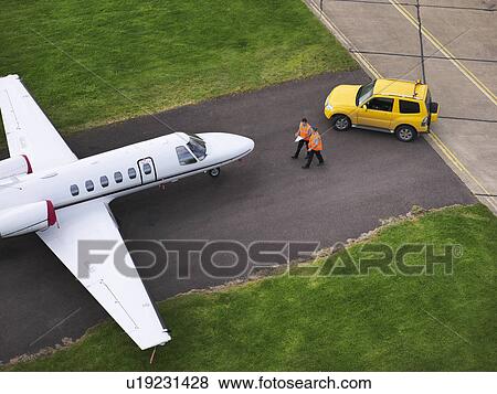 Engineers with jet aircraft on runway View Large Photo Image Stock Photo - Engineers with jet aircraft on runway. Fotosearch