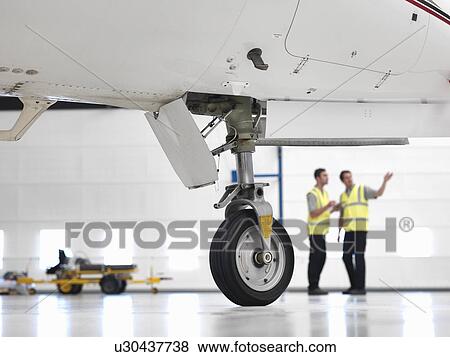 Engineers with jet aircraft wheel View Large Photo Image Stock Photo - Engineers with jet aircraft wheel. Fotosearch