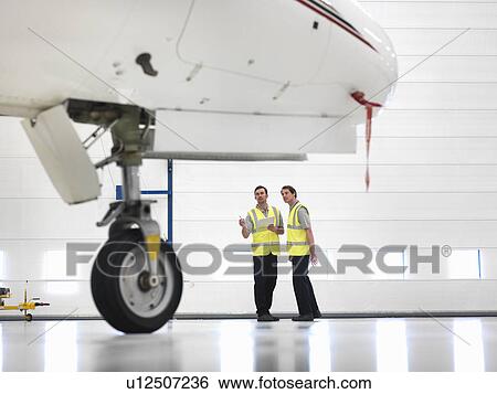 Stock Photograph - Engineers with jet aircraft wheel. Fotosearch