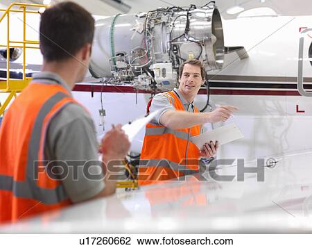 Stock Image - Engineers with jet engine. Fotosearch