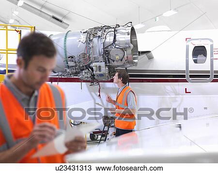 Stock Image - Engineers with jet engine. Fotosearch