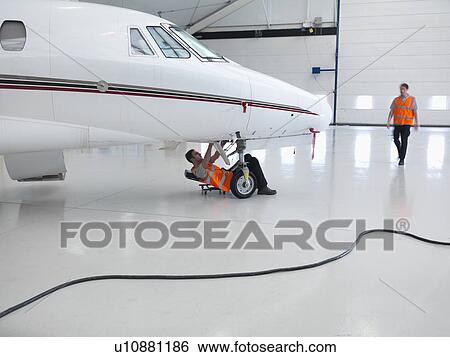 Stock Photograph - Engineers working on jet aircraft. Fotosearch