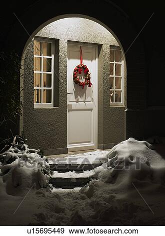 Stock Photo - Entrance of a house at christmas eve. Fotosearch