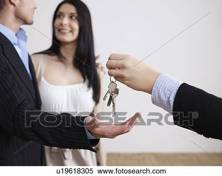 Estate agent hands keys to couple View Large Photo Image Stock Photography - Estate agent hands keys to couple. Fotosearch