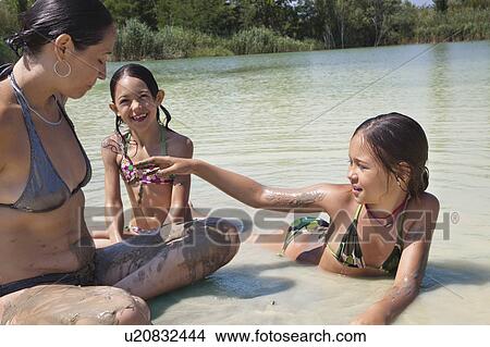 Family playing together in a muddy lake View Large Photo Image Picture - Family playing together in a muddy lake. Fotosearch