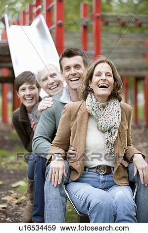 Stock Photo - Family portrait on a slide in the park. Fotosearch