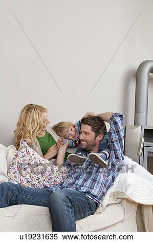 Stock Photography - Family sitting on couch. Fotosearch