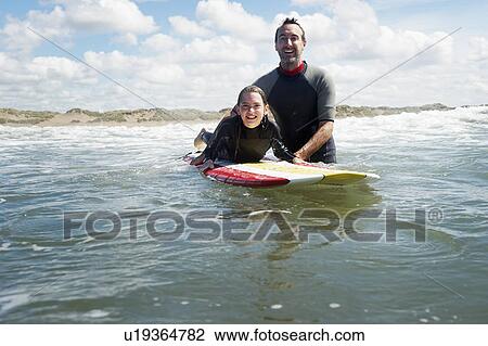 Father and daughter surfing in the sea View Large Photo Image Stock Image - Father and daughter surfing in the sea. Fotosearch