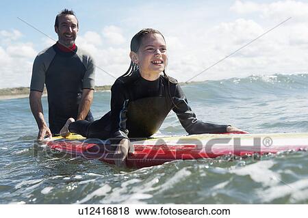 Father and daughter surfing together View Large Photo Image Stock Photo - Father and daughter surfing together. Fotosearch