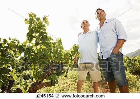 Stock Image - Father and son in vineyard. Fotosearch