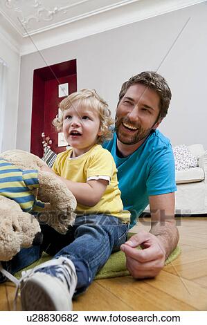 Father and son playing on floor View Large Photo Image Stock Image - Father and son playing on floor. Fotosearch