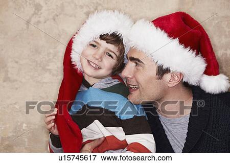 Father and son wearing Santa hats View Large Photo Image Stock Photo - Father and son wearing Santa hats. Fotosearch
