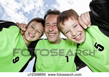 Stock Photography - Father and sons team pep talk. Fotosearch