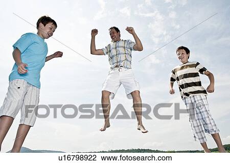 Father and two sons jumping View Large Photo Image Stock Image - Father and two sons jumping. Fotosearch