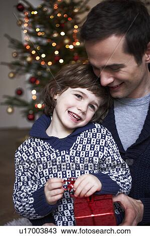 Stock Image - Father giving son present. Fotosearch