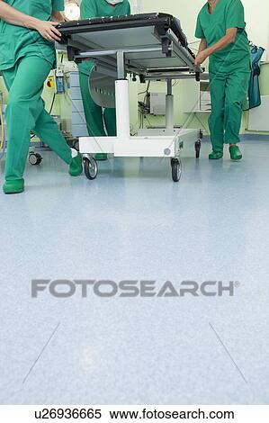 Stock Photography - Feet in scrubs pushing couch. Fotosearch
