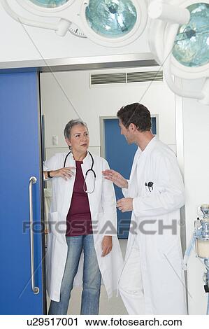 Stock Image - Female and male doctor discussing. Fotosearch