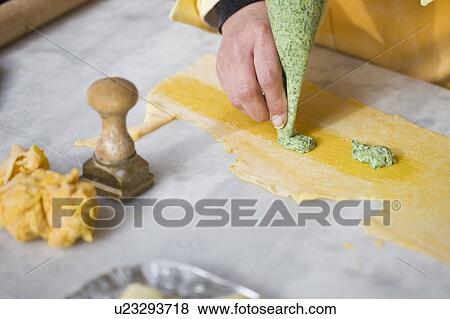 Stock Photo - Filling the pasta dough. Fotosearch
