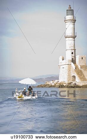 Stock Image - Fisher boat and light house. Fotosearch