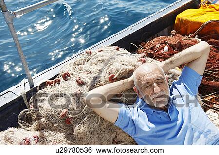 Stock Photograph - Fisherman asleep on nets. Fotosearch