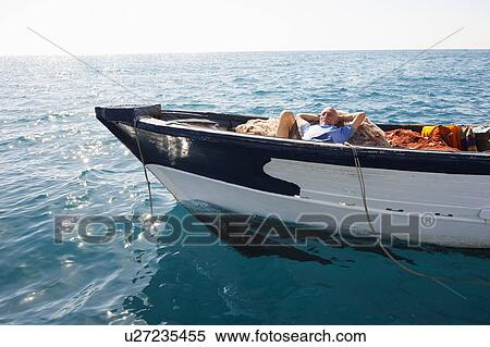 Stock Photography - Fisherman asleep on nets. Fotosearch