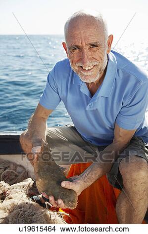 Fisherman holding fish View Large Photo Image Picture - Fisherman holding fish. Fotosearch
