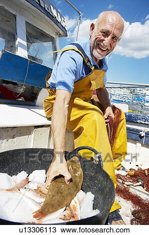 Stock Image - Fisherman holding fish. Fotosearch