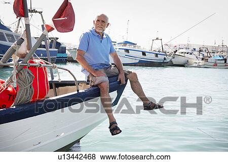 Stock Photo - Fisherman sitting on boat. Fotosearch