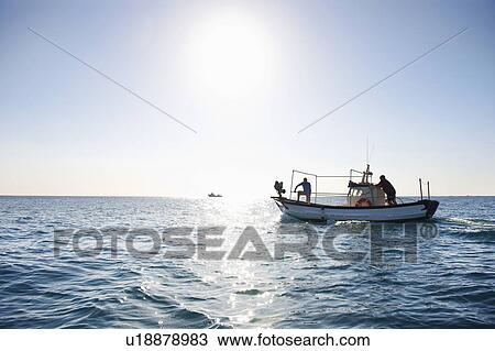 Stock Image - Fishermen on fishing boat at sea. Fotosearch