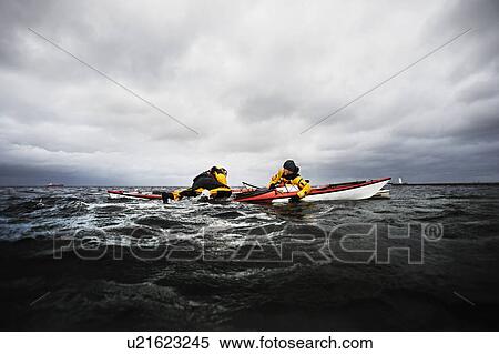 Stock Photography - Freinds in kayak helping each other. Fotosearch